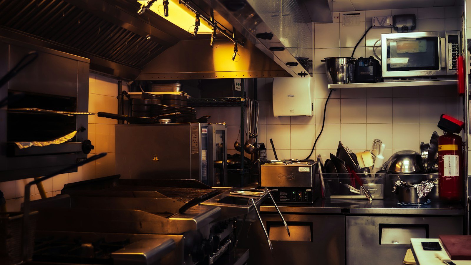 مطبخ تجاري بمعدات طهي وطفاية حريق | Commercial kitchen with cooking equipment and a fire extinguisher